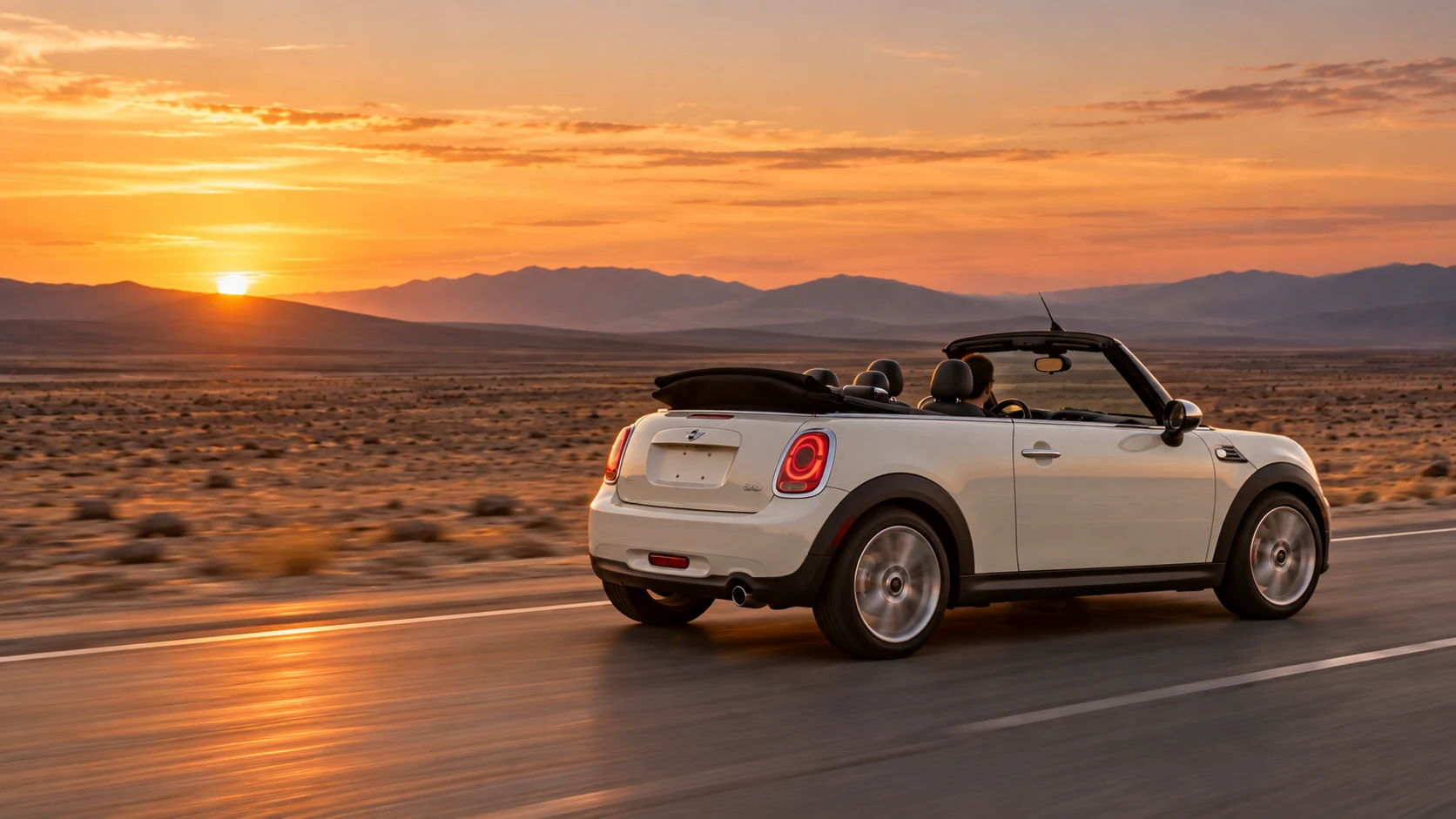 夕焼けの大地を走る白いMINI R57コンバーチブルのイメージ